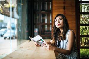 Hermosa mujer leyendo una revista en el café foto