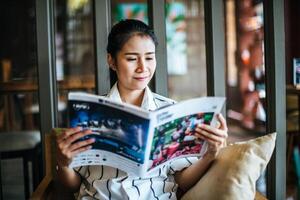 Beautiful woman reading magazine in cafe photo