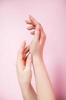 Beautiful female hands on pink background. Spa and body care concept. Image for advertising. photo