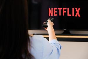 chiang mai tailandia, 07 de junio de 2020: una joven ve netflix en su televisor y en casa. foto