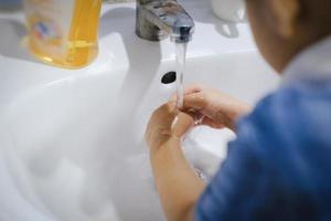 niño lavándose las manos con jabón para limpiar los gérmenes del virus corona.