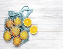 bolso de compras de malla con naranjas foto