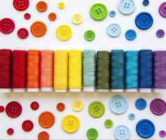 Spools of thread and buttons on the colors  of the rainbows