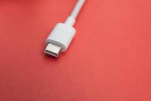 Cable USB tipo C sobre fondo rojo. foto