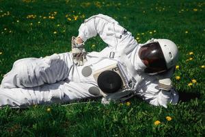 Astronauta futurista en un casco sobre un césped verde foto