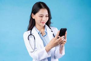 portrait of young female doctor, isolated on blue background photo