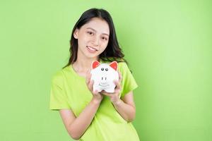 asian girl holding piggy bank in her hand money saving concept photo