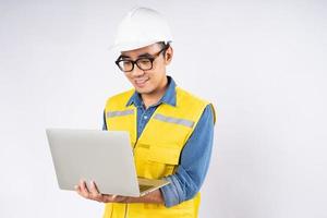 Smiling young asian civil engineer wearing helmet hard hat standing on isolated white background. Mechanic service concept. photo