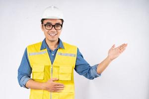 Smiling young asian civil engineer wearing helmet hard hat standing on isolated white background. Mechanic service concept. photo