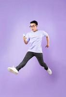 Portrait of a jumping asian man, isolated on purple background photo