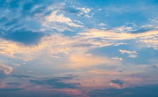 Sky blue and orange light of the sun through the clouds in the sky photo