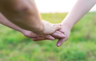 Close-up of young people putting their hands together. Friends holding hands show solidarity and teamwork. photo