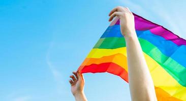 image of lgbt flag fluttering in the blue sky photo