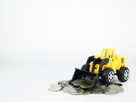 Toy Bulldozers with coins on white background, Business concept photo