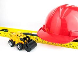 Red safety helmet and Balance ruler on white background, Engineering construction concept photo