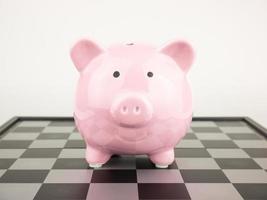 Pink piggy bank on chess board photo