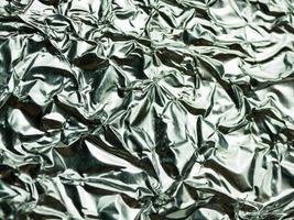 Silver foil with shiny crumpled texture background photo