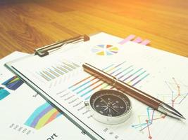 Business report chart and Financial graph analysis with pen and compass on table photo