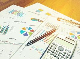 Cuadro de informe comercial y análisis de gráfico financiero con lápiz y calculadora en la mesa foto