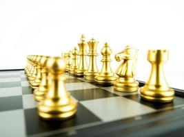 Figuras de ajedrez de oro a bordo para el inicio del juego, el deporte intelectual y el juego táctico. foto