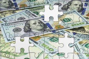 Missing jigsaw puzzle pieces on money dollar background photo