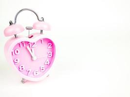 Pink alarm clock in the form of heart isolated on white background, Valentine's Day photo