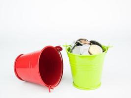 Money coins in green bucket on white background, Business concept photo