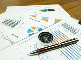 Business report chart and Financial graph analysis with pen and compass on table photo