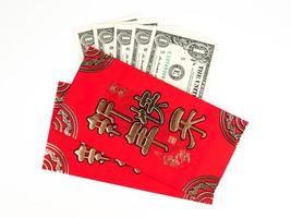 sobre rojo aislado sobre fondo blanco con dinero en dólares para regalo de año nuevo chino. texto chino en el sobre que significa feliz año nuevo chino foto