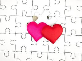 Colorful mini hearts on jigsaw puzzle pieces background, Valentine decorations, Various hearts photo