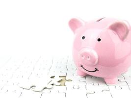 Pink piggy bank with jigsaw puzzle, economy concept photo