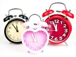 Three alarm clock, red, pink, black isolated on white background photo