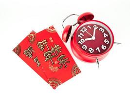 sobre rojo aislado sobre fondo blanco con despertador rojo para regalo de año nuevo chino. texto chino en el sobre que significa feliz año nuevo chino foto