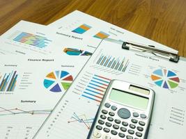 Business report chart and Financial graph analysis with calculator on table photo