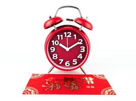 Red envelope isolated on white background with Red alarm clock for gift Chinese New Year. Chinese text on envelope meaning Happy Chinese New Year photo