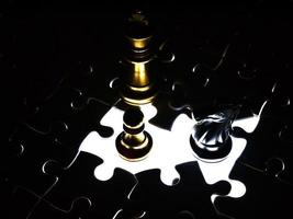 Gold and silver chess piece on jigsaw puzzle background, business concept photo