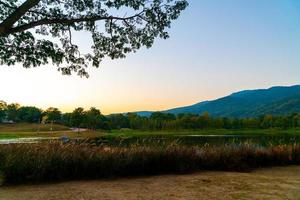 hermoso lago en chiang mai con montañas boscosas y cielo crepuscular foto