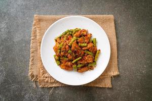 Stir fried pork and red curry paste with sting bean photo