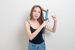 portrait beautiful Asian woman using hair curler or curling iron photo
