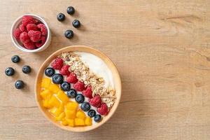 homemade yogurt bowl with raspberry, blueberry, mango and granola photo