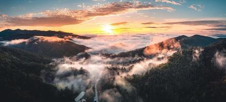 el sol sale en la niebla y las montañas por la mañana foto