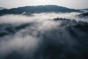 el sol sale en la niebla y las montañas por la mañana foto