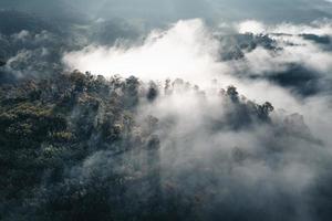 el sol sale en la niebla y las montañas por la mañana foto