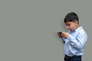 concepto de ocio, niños, tecnología y personas - niño sonriente con teléfono inteligente o jugando en casa espacio de copia foto