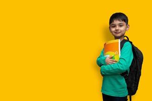 Child boy with book and bag on shoulders going to school concept copy space photo