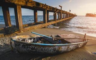 Small fishery wooden boat on the beach. photo