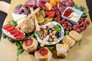 mixed antipasto platter with cold cuts and legumes and cheeses photo