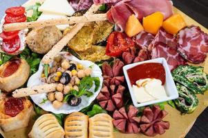 mixed antipasto platter with cold cuts and legumes and cheeses photo