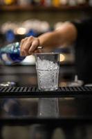 woman's hand pouring liquor into a glass photo