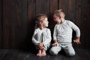 Two children, brother and sister in pajamas play together photo